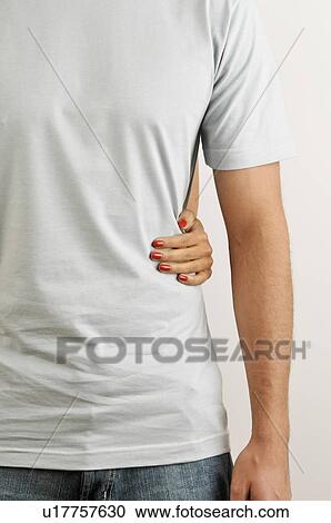 Stock Image - Female hand around young adult male's waist. Fotosearch