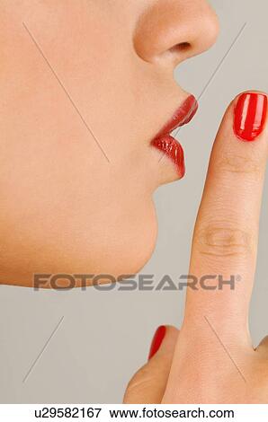 Stock Photo - Female young adult closeup; finger to lips. Fotosearch