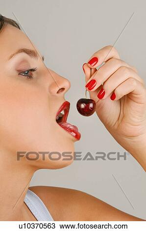 Female young adult eating a cherry View Large Photo Image Stock Image - Female young adult eating a cherry. Fotosearch