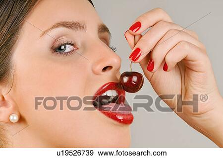 Female young adult eating a cherry View Large Photo Image Stock Photo - Female young adult eating a cherry. Fotosearch