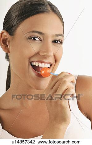Female young adult eating a lollipop View Large Photo Image Stock Image - Female young adult eating a lollipop. Fotosearch