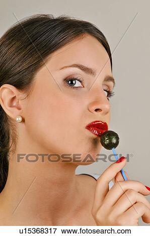 Female young adult eating a lollipop View Large Photo Image Stock Photo - Female young adult eating a lollipop. Fotosearch