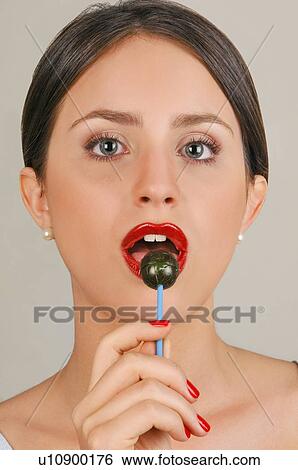 Stock Photograph - Female young adult eating a lollipop. Fotosearch
