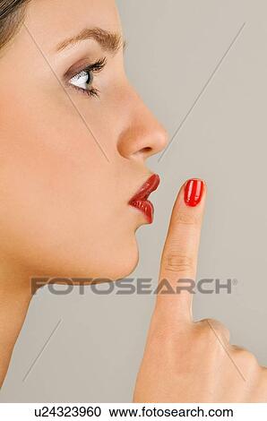 Stock Image - Female young adult; finger to lips. Fotosearch