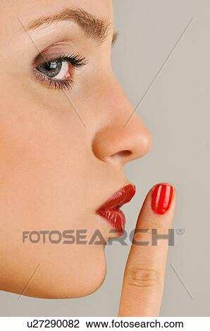 Stock Image - Female young adult; finger to lips. Fotosearch