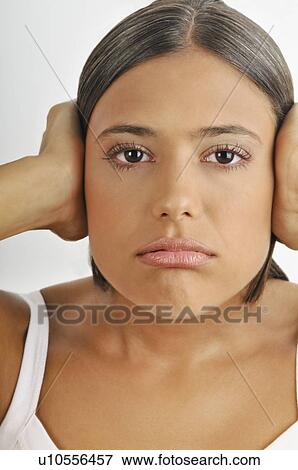 Stock Photo - Female young adult; hands holding ears. Fotosearch