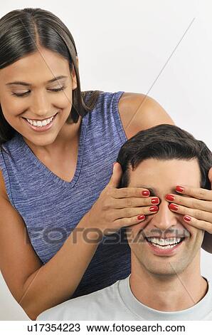 Female young adult holding hands over man's eyes View Large Photo Image Stock Image - Female young adult holding hands over man's eyes. Fotosearch