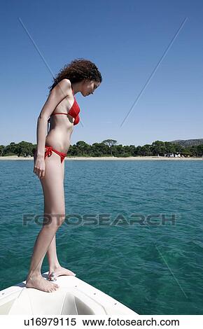 Stock Photography - Female young adult looking into sea. Fotosearch