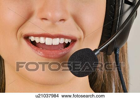 Picture - Female young adult mouth with microphone headset. Fotosearch