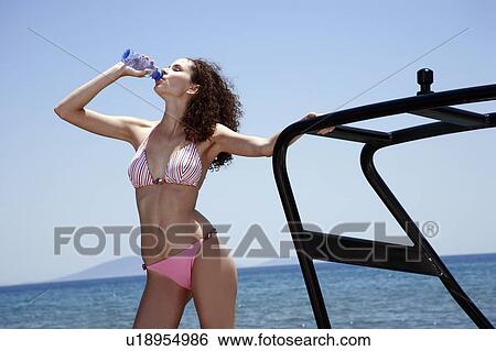 Female young adult on boat drinking water View Large Photo Image Stock Photograph - Female young adult on boat drinking water. Fotosearch