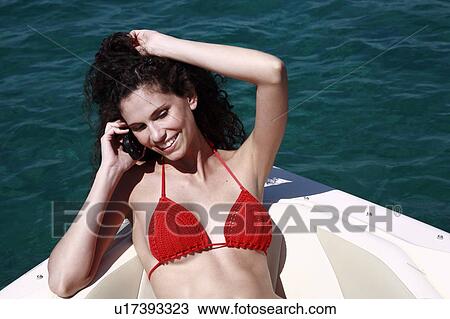 Female young adult on boat on cell phone View Large Photo Image Stock Image - Female young adult on boat on cell phone. Fotosearch