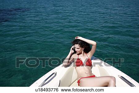 Female young adult on boat on cell phone View Large Photo Image Stock Photograph - Female young adult on boat on cell phone. Fotosearch