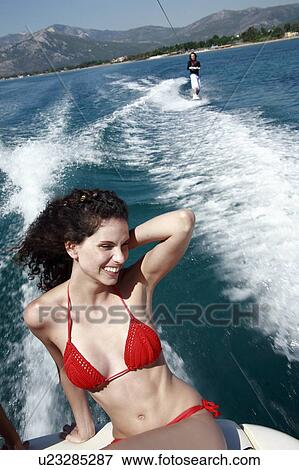 Female young adult on speedboat; male waterskiing View Large Photo Image Stock Photo - Female young adult on speedboat; male waterskiing. Fotosearch