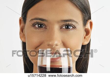 Stock Photo - Female young adult smelling a glass of red wine. Fotosearch