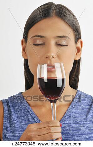 Stock Photograph - Female young adult smelling a glass of red wine. Fotosearch