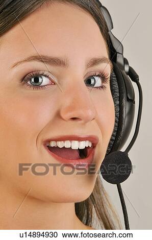 Stock Image - Female young adult with microphone headset. Fotosearch