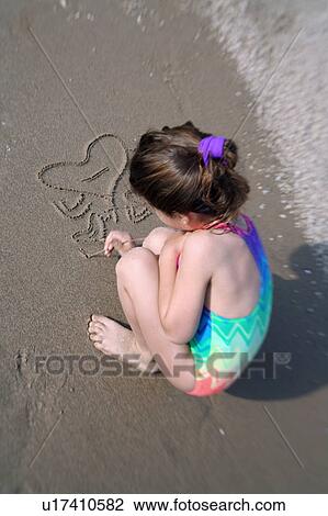 Girl drawing in the sand View Large Photo Image Stock Image - Girl drawing in the sand. Fotosearch