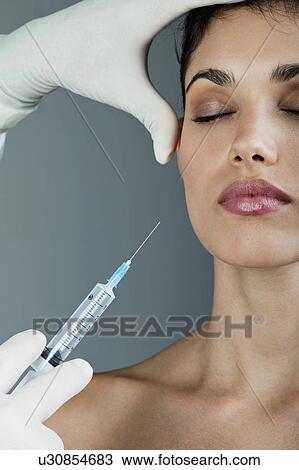 Hand holding botox syringe to young woman's face View Large Photo Image Stock Image - Hand holding botox syringe to young woman's face. Fotosearch