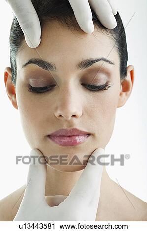 Hands wearing surgical gloves holding young woman's face View Large Photo Image Stock Image - Hands wearing surgical gloves holding young woman's face. Fotosearch