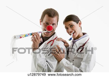 Stock Photo - Male and female doctors with party toys. Fotosearch