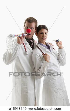 Stock Photo - Male and female doctors with party toys. Fotosearch