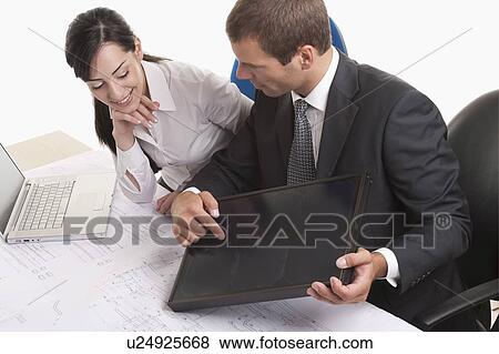 Stock Photo - Man and woman looking at solar panel. Fotosearch