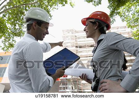 Man and woman with hardhats at construction site View Large Photo Image Stock Image - Man and woman with hardhats at construction site. Fotosearch