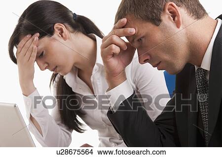 Picture - Man and woman with heads in hands. Fotosearch