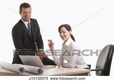 Man and woman with plans and laptop at desk View Large Photo Image Stock Image - Man and woman with plans and laptop at desk. Fotosearch