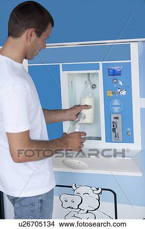 Man filling milk bottle at cooler View Large Photo Image Picture - Man filling milk bottle at cooler. Fotosearch