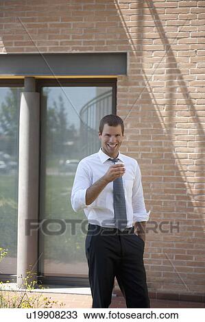 Man holding cup outside building View Large Photo Image Stock Image - Man holding cup outside building. Fotosearch