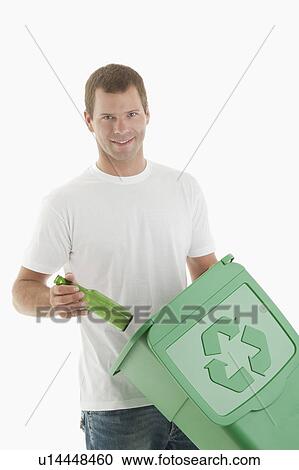 Stock Image - Man throwing glass bottle in the recycling bin. Fotosearch