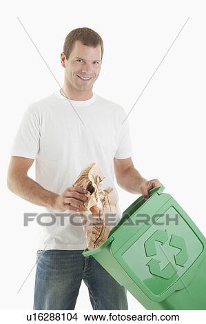 Picture - Man throwing paper in the recycling bin. Fotosearch