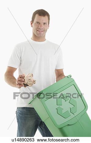 Stock Image - Man throwing paper in the recycling bin. Fotosearch