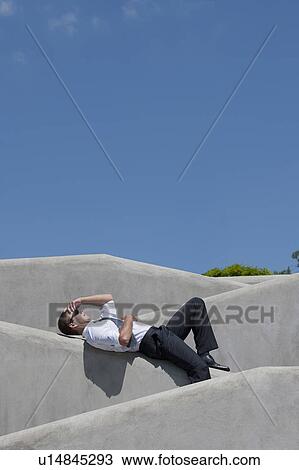 Man with tie and sunglasses lying down on wall View Large Photo Image Stock Image - Man with tie and sunglasses lying down on wall. Fotosearch