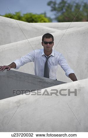 Man with tie and sunglasses standing behind wall View Large Photo Image Stock Image - Man with tie and sunglasses standing behind wall. Fotosearch