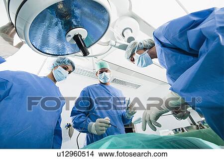 Picture - Medical personnel in operating room. Fotosearch