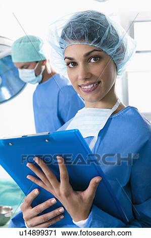 Stock Image - Medical personnel in operating room. Fotosearch