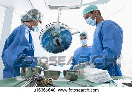 Stock Image - Medical personnel in operating room. Fotosearch