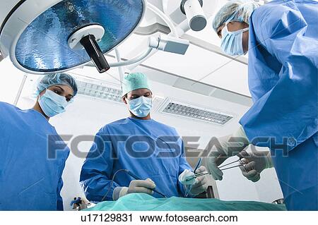 Stock Image - Medical personnel in operating room. Fotosearch