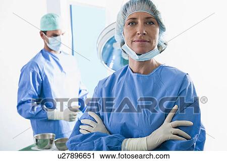 Stock Image - Medical personnel in operating room. Fotosearch