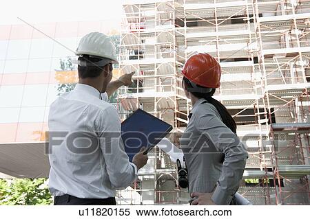 Professionals with hardhats at construction site View Large Photo Image Stock Photography - Professionals with hardhats at construction site. Fotosearch