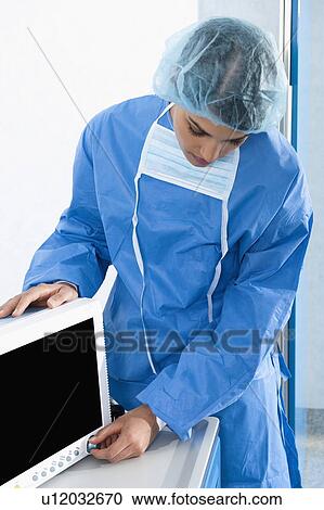 Surgeon adjusting monitor in operating room View Large Photo Image Stock Image - Surgeon adjusting monitor in operating room. Fotosearch
