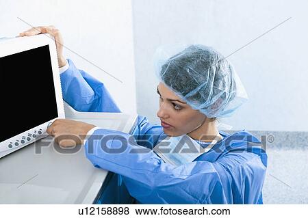 Surgeon adjusting monitor in operating room View Large Photo Image Stock Photo - Surgeon adjusting monitor in operating room. Fotosearch