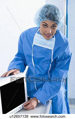 Stock Photo - Surgeon adjusting monitor in operating room. Fotosearch