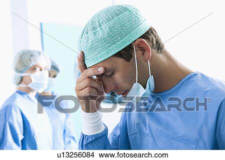 Picture - Surgeon under stress in operating room. Fotosearch