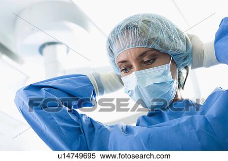 Surgeon wearing surgical mask in operating room View Large Photo Image Stock Photography - Surgeon wearing surgical mask in operating room. Fotosearch