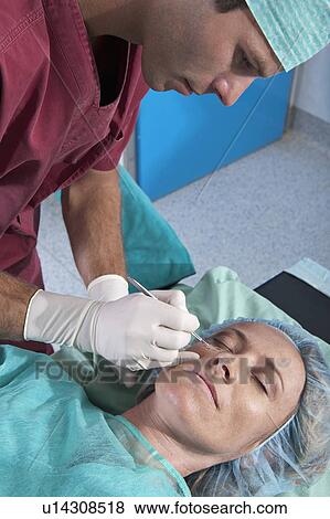 Surgeon with scalpel to patient's face View Large Photo Image Stock Photo - Surgeon with scalpel to patient's face. Fotosearch