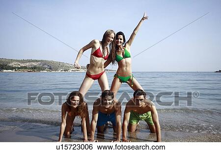 Stock Photograph - Two male and three female young adults in the sea. Fotosearch