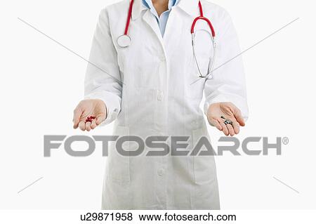Stock Photo - View of doctor's torso holding pills in each hand. Fotosearch